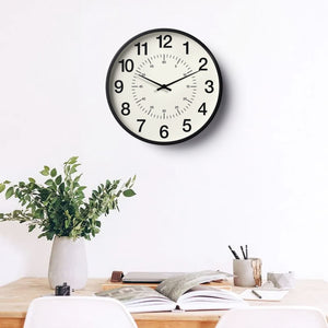 Classic Wall Clock – Bold Numeral Minimal Design on a white wall above a desk with plants.